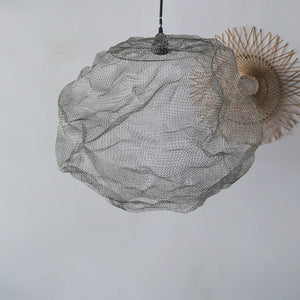 Handmade wire mesh pendant lamp with organic shape against a white wall