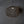 Handwoven rattan pendant light with organic shape hanging from ceiling against gray wall
