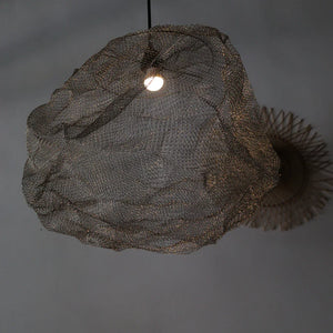 Handmade wire mesh pendant light with organic shape hanging from ceiling
