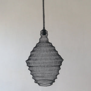 Handmade black wire pendant lamp with organic shape against neutral wall