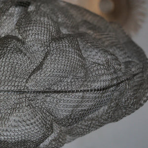 Close-up of a decorative wire mesh lampshade with intricate handmade patterns