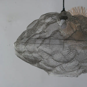 Handmade wire mesh pendant lamp with organic cloud-like shape against a neutral wall