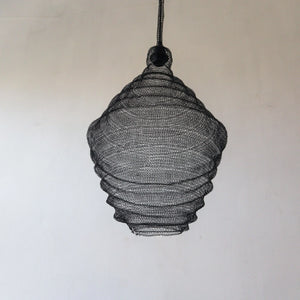 Handmade black mesh pendant light with organic shape against neutral wall