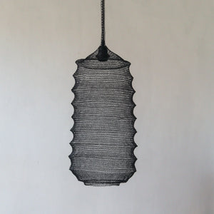 Handmade woven rattan pendant light with textured black finish against white wall