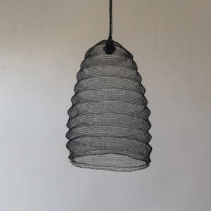 Handmade black mesh pendant light with a textured beehive shape against a plain wall