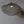 Handwoven rattan pendant light with intricate leaf pattern, hanging from a ceiling
