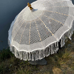 Handmade Balinese crochet umbrella with wooden finial and fringed edges outdoors