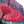 Handmade Balinese umbrella in vibrant pink with blue tassels, showcasing intricate design and craftsmanship.
