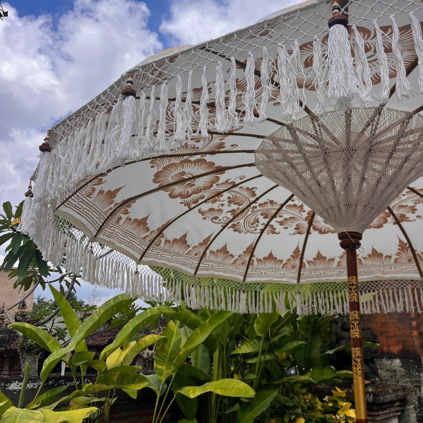 Decorative umbrella with tassels in a garden setting