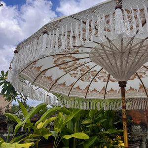 Decorative umbrella with tassels in a garden setting