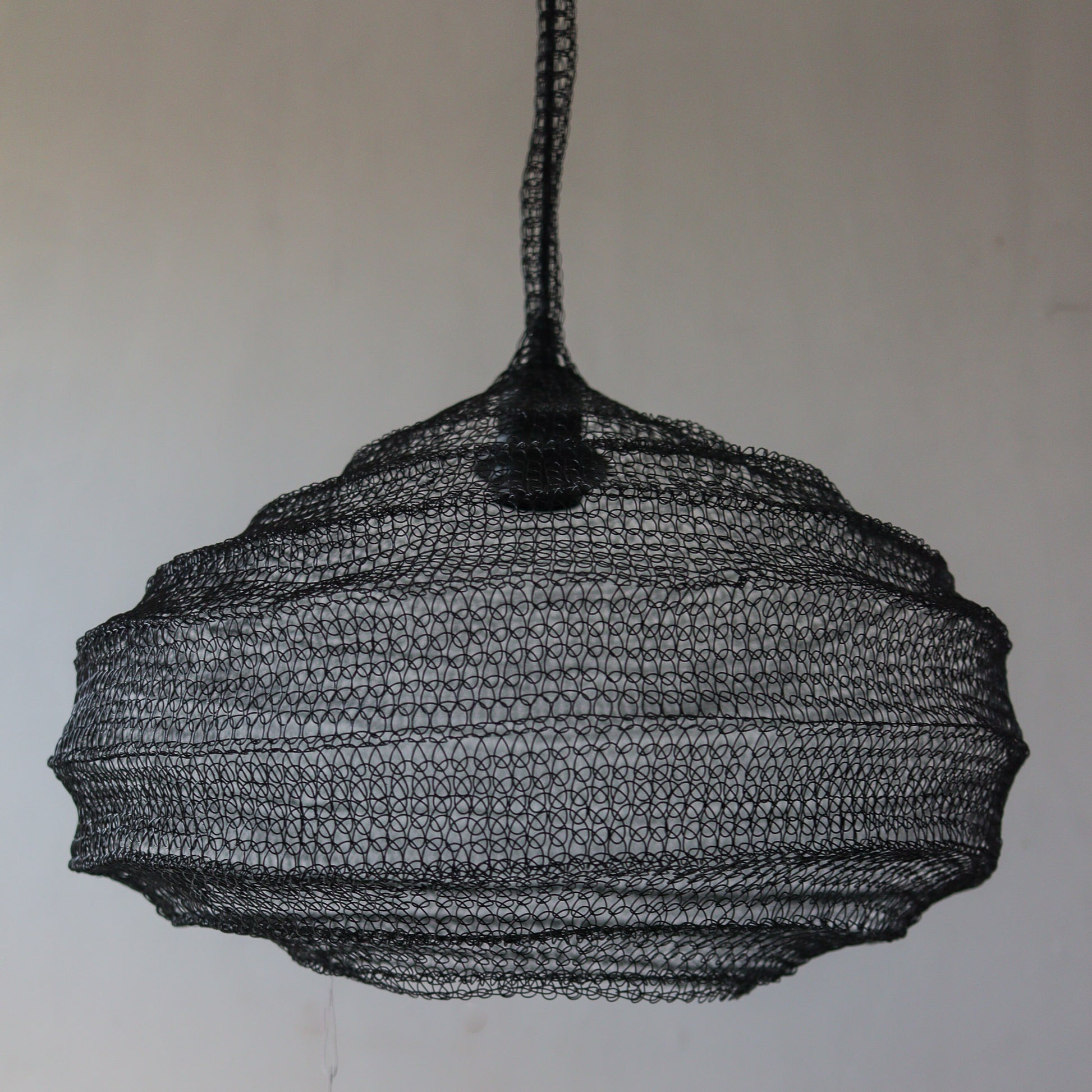 Black wire mesh chandelier design, handcrafted in Bali, with unique motifs and customizable options.