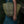 Hand holding natural woven tote bag, eco-friendly craftsmanship, green dress in background