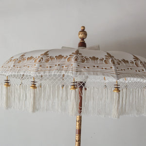 Hand painted Balinese parasol in white with intricate gold design and fringe, handmade in Bali, Indonesia.