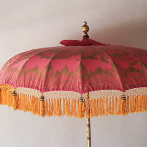 Balinese pink and gold parasol with ornate patterns and yellow fringe, handmade decor
