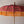 Balinese decorative umbrella with pink and gold fabric, wooden pole, and yellow fringe tassels