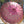 Balinese pink parasol with gold floral patterns and tassel fringe, outdoor setting