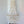 Handmade seashell chandelier with layered white shell pieces hanging in a minimalist room