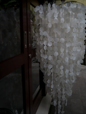 Handmade Balinese seashell chandelier with cascading capiz shells by glass doors