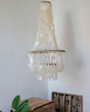 Handmade Balinese seashell chandelier hanging in a minimalist, eco-friendly interior