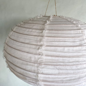 Handmade round fabric pendant lamp with textured natural fibers hanging indoors