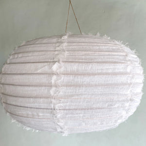 Handmade white linen pendant lamp with textured details on a neutral wall background