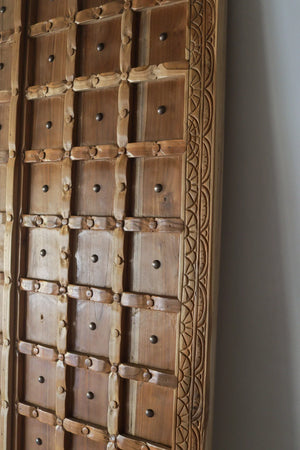 Hand-carved wooden door with decorative patterns and metal studs, Balinese home decor