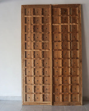 Hand-carved wooden Balinese double door with intricate frame and square panel design