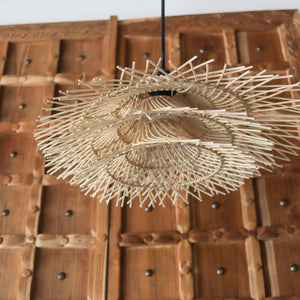 Handcrafted tiered rattan pendant light with unique jerami design, showcasing intricate patterns and natural beauty.