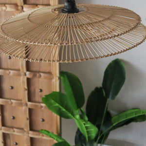 Handcrafted rattan pendant light with two-tiered design, showcasing unique Bali craftsmanship against a natural backdrop.
