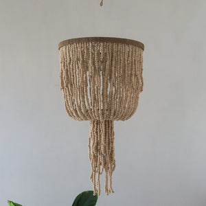 Handmade Balinese beaded seashell chandelier with natural neutral tones, hanging indoors