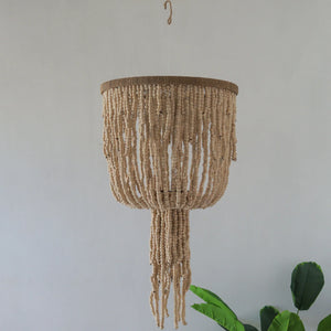 Handmade Balinese beaded chandelier with natural wood beads, hanging in a minimalist room