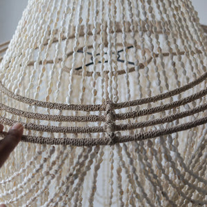 Handmade seashell chandelier with natural woven frame and cascading shell strands