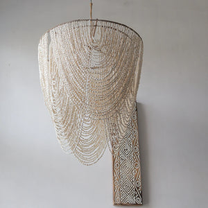 Handmade seashell chandelier with cascading strands and carved wooden wall art decor