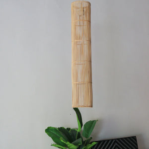 Handcrafted rattan pendant light in tube design, showcasing natural variations and artisan craftsmanship.