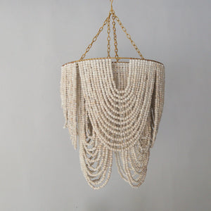 Beaded chandelier in gold and white, handcrafted in Bali, perfect for stylish home décor.