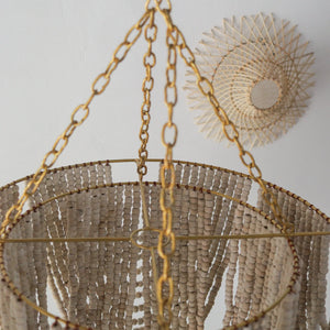 Handcrafted beaded chandelier in gold, featuring a unique white wash finish, showcasing Bali artistry.