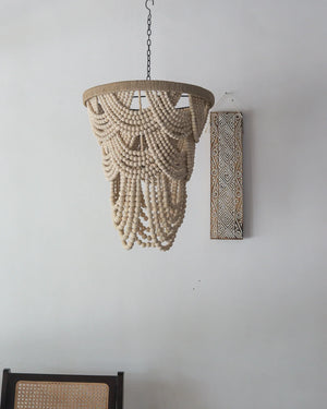 Handmade Balinese wooden bead chandelier with natural decor on white wall