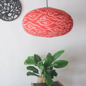 Oval-shaped batik fabric chandelier in vibrant red, perfect for unique home decor. Handmade in Bali, offering international shipping.