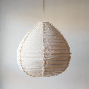 Handmade fabric pendant light with a textured, teardrop shape, hanging indoors