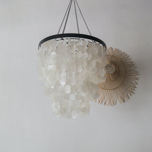 Capiz shell chandelier in black and white design, handmade in Bali, hanging elegantly from the ceiling.