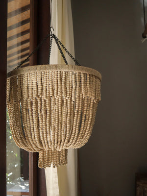 Handmade Balinese wooden bead chandelier hanging by a window in natural light