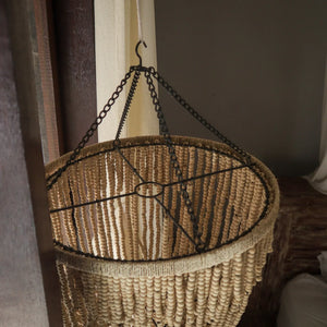 Handmade beaded chandelier with metal chain in natural light, Balinese home decor style
