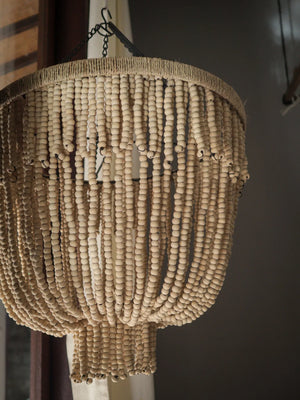Handmade wooden bead chandelier with layered boho design, hanging in a modern interior