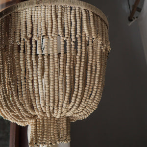 Handmade Balinese wood bead chandelier with natural finish, hanging in a modern interior.