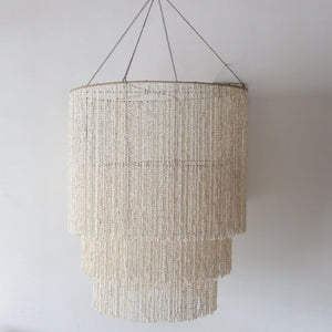 Handmade large seashell chandelier with tiered design, crafted in Bali, Indonesia, featuring cascading shell strands.