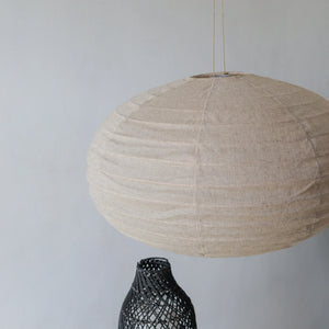 Handmade natural linen pendant lamp with woven texture in minimalist decor setting