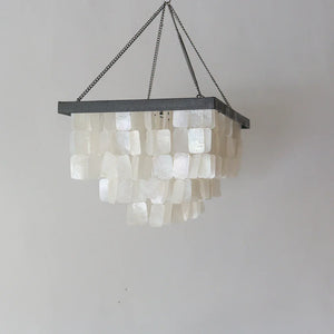 Handmade Balinese seashell chandelier with cascading white shells and black metal frame