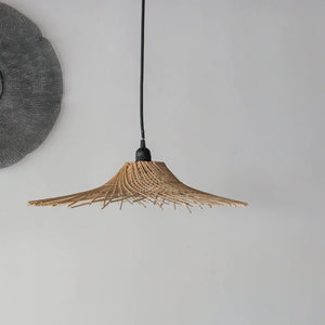 Handcrafted rattan pendant light with natural woven pattern against a neutral wall.