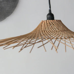 Handwoven rattan pendant light with natural bamboo shade in minimalist interior
