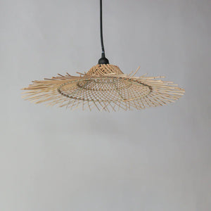 Handwoven rattan pendant light with intricate openwork design, boho home decor.